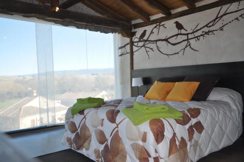 1 dormitorio con 1 cama con un pájaro en la pared en Suite rural con jacuzzi, en Cabañas de Polendos