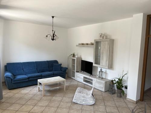a living room with a blue couch and a tv at Cà del Fili in Lenno