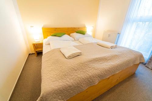 a bedroom with two beds with white sheets and a window at Aparthotel Belveder in Tatranská Lomnica