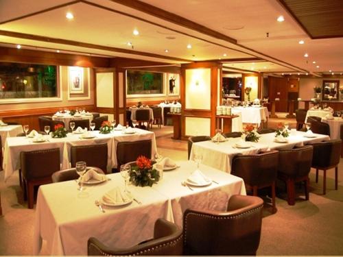 a restaurant with tables and chairs with white tablecloths at Hotel Continental Porto Alegre e Centro de Eventos in Porto Alegre