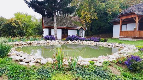 a garden with a pond in front of a house at Belvárdi Fogadó in Belvárdgyula