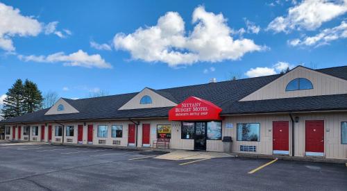 un edificio con una señal roja en un estacionamiento en Nittany Budget Motel en State College