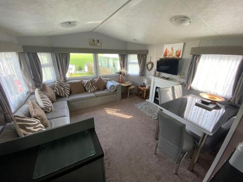 a living room with a couch and a table at Superb luxury two bed caravan, Todber Valley Holiday Park, sleeps six in Gisburn