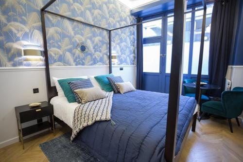 巴黎的住宿－Le Café des Invalides，一间卧室配有一张天蓬床和蓝色的墙壁