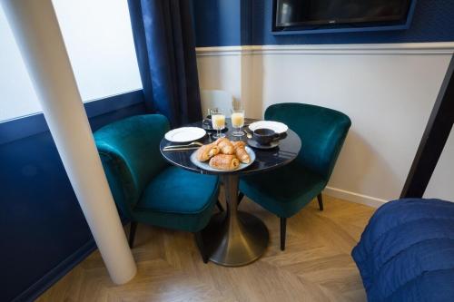 巴黎的住宿－Le Café des Invalides，一张桌子和椅子,上面有一盘食物
