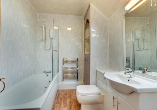 a white bathroom with a sink and a toilet and a tub at Ty Newydd in Dolgellau