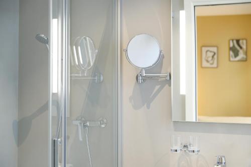 a bathroom with a shower and a mirror at Boutique Hotel Piazza Grande in Locarno
