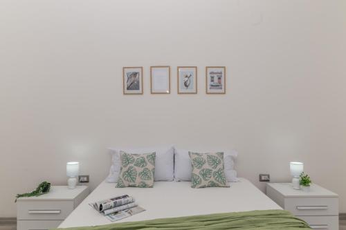 una camera bianca con un letto e due comodini di Casa Belvedere With A/C - Happy Rentals a Codrongianos