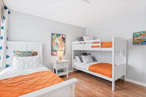 1 dormitorio con 2 literas y 1 cama naranja en The Sanddollar Castle, en St. Augustine