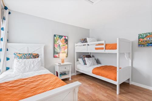 a bedroom with two bunk beds and an orange bed at The Sanddollar Castle in St. Augustine