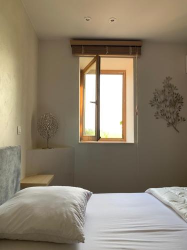 a bedroom with a white bed and a window at B&B elzartwinning in Hasselt