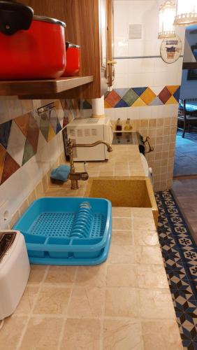 cocina con fregadero azul y encimera en La Cocineta - Zaracatralla, en Alquézar