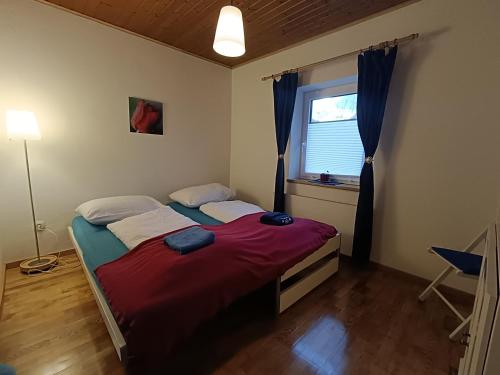 a bedroom with a red bed and a window at Stylish & Spacious Apartment with Patio in Stams