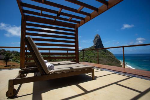 a chair on a balcony with a view of the ocean at Pousada Ecológica Akanã in Fernando de Noronha