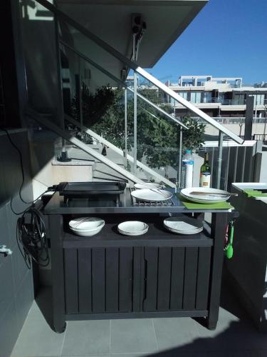 a table with four plates on it on a balcony at Modern apartment 250m from the sea with parking space behind gate in Pilar de la Horadada