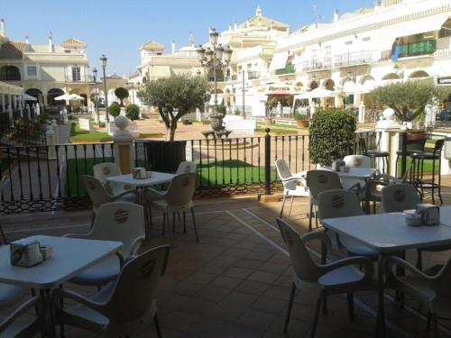 a patio with tables and chairs in front of a building at Modern apartment 250m from the sea with parking space behind gate in Pilar de la Horadada