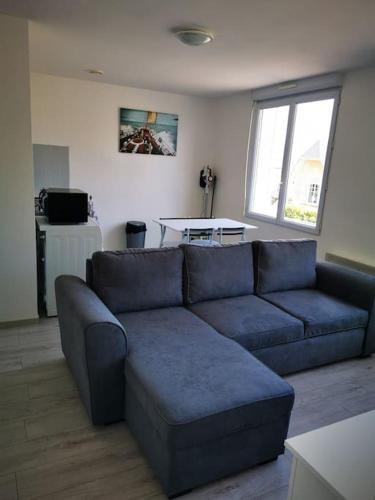 a living room with a blue couch and a table at Appartement lumineux 2 pièces, 4 couchages in Saint-Jean-de-Monts