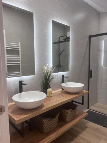 two sinks on a wooden counter in a bathroom at Apartamento Centro León GVSM in León