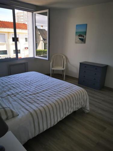 une chambre avec un lit, une commode et une fenêtre dans l'établissement Appartement lumineux 4 personnes, à Saint-Jean-de-Monts