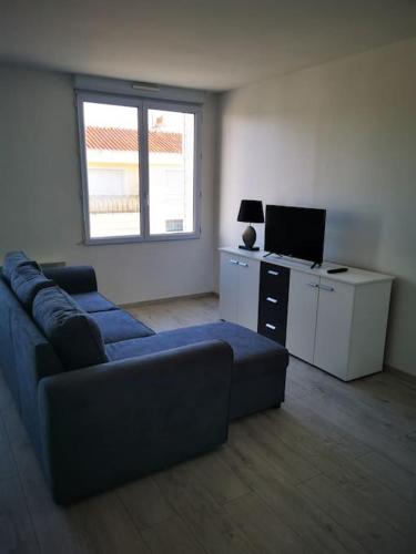 sala de estar con sofá y escritorio con ordenador en Appartement lumineux 2 pièces, 4 couchages en Saint-Jean-de-Monts