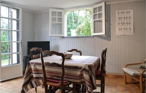 ein Esszimmer mit Tisch und Stühlen und zwei Fenstern in der Unterkunft Beautiful Apartment In Capbreton in Capbreton