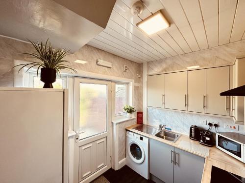 a kitchen with a sink and a washing machine at Spacious House 4 Bedrooms, 2 Bathrooms - Short & Long Stays, Contractors - Leisure in Derby