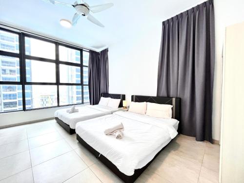 two beds in a room with large windows at Golden House-Atlantis Residence in Malacca