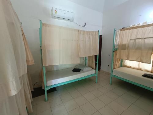 a room with two bunk beds and a window at Molly's Hostel in Varkala