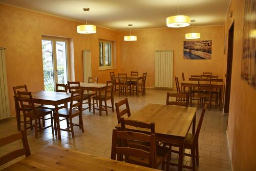 uma sala de jantar com mesas e cadeiras de madeira em Hotel Aquila em Scoppito