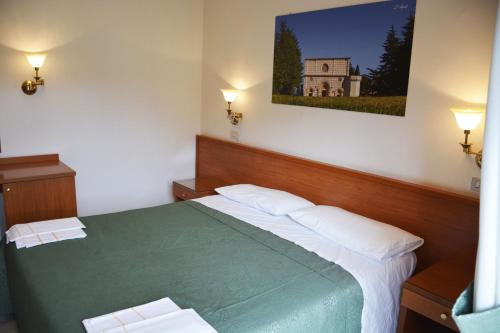 um quarto com uma cama verde e 2 almofadas brancas em Hotel Aquila em Scoppito