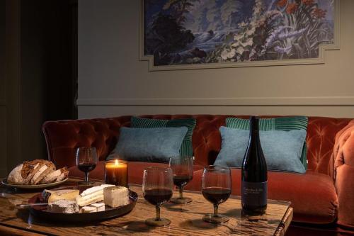 uma mesa com uma garrafa de vinho e copos de vinho em My Boudoir em Paris