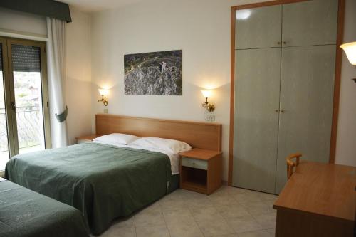 a hotel room with two beds and a desk at Hotel Aquila in Scoppito