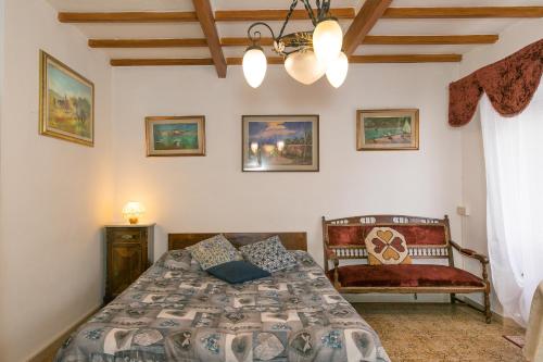 1 dormitorio con cama y banco. en Appartamento Stella, en Chianni