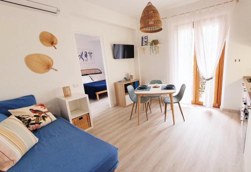 ein Wohnzimmer mit einem blauen Bett und einem Tisch in der Unterkunft NUMANA SEA APARTMENT in Numana