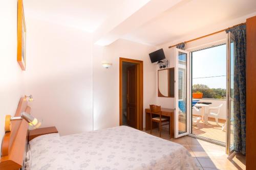 a hotel room with a bed and a balcony at Hotel Villa Fumerie in Ischia