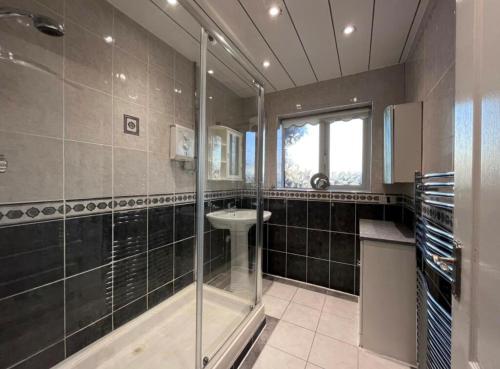 a bathroom with a glass shower and a sink at Solihull 5 Bed Home near NEC/Bham airport/JLR/HS2 in Solihull