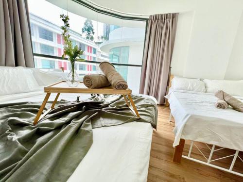 een woonkamer met 2 bedden en een tafel bij G2 1-8Paxs Cozy Home Sunway Medical Geo SmrtTV 3bed in Kampong Penaga