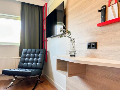 a black leather chair sitting next to a desk in a room at Good Morning Jönköping in Jönköping