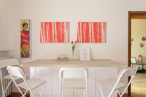 a dining room with white chairs and a table at Casa Cairoli in Mira