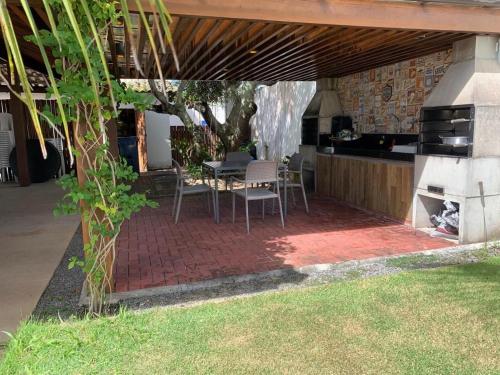 a patio with a table and chairs and a grill at Reserva Eco Itacimirim in Camaçari