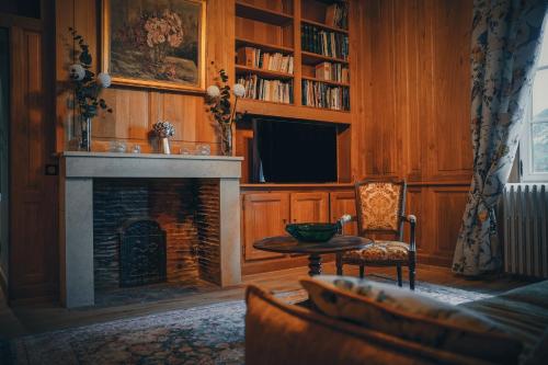 a living room with a fireplace and a table at Château Ecrin de Lumière in Campsegret