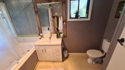 ein Badezimmer mit einem Waschbecken, einer Badewanne und einem WC in der Unterkunft The Hammock 