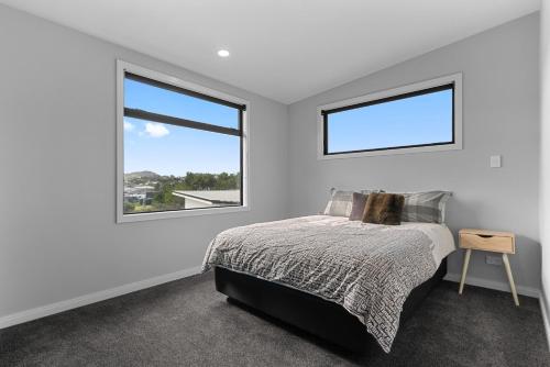 - une chambre blanche avec un lit et une fenêtre dans l'établissement Fuel for the Sol - Mangawhai Heads Holiday Home, à Mangawhai