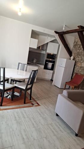 une cuisine et un salon avec une table et des chaises dans l'établissement Appartement 1chambre et 1salon, à Cepoy