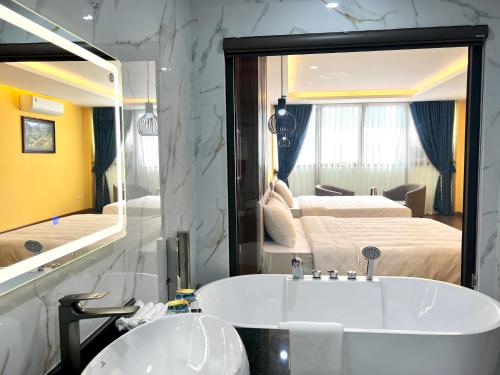 a bathroom with a tub and a large mirror at An Khang Hotel Sapa in Sapa