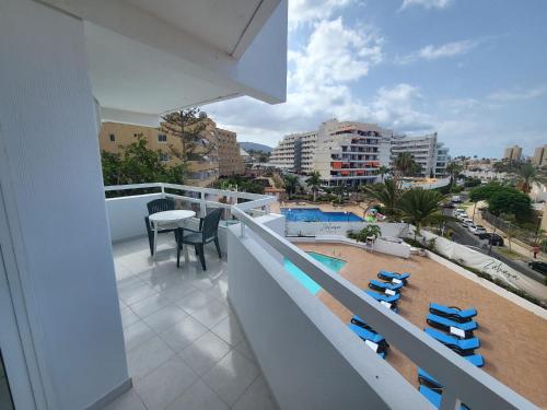 a balcony with chairs and a view of a city at Cozy Apartment near the beach in Playa de las Americas