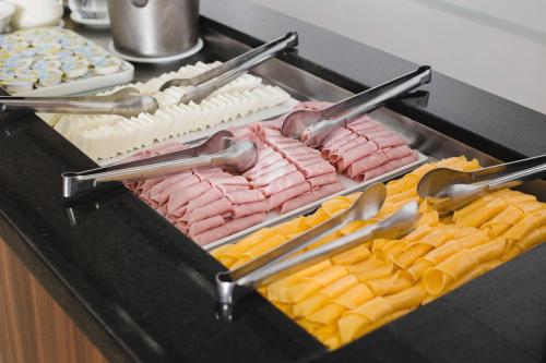 a tray of meats and cheese on a grill at Al Mare Hotel in Florianópolis