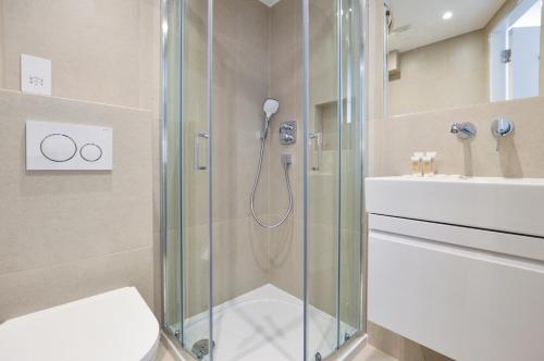 a bathroom with a shower and a toilet and a sink at Regents Serviced Apartments by StayPrime in London