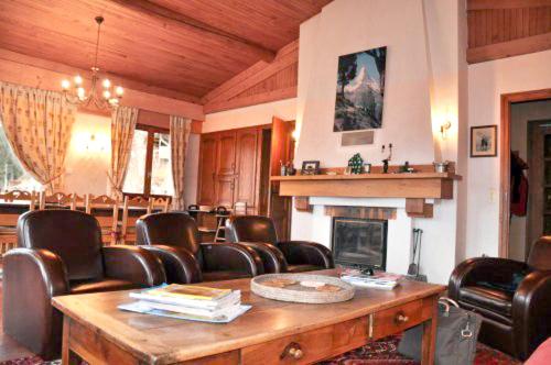 a room with leather chairs and a table and a fireplace at Chalet de 5 chambres avec vue sur la ville terrasse amenagee et wifi a Cordon in Cordon