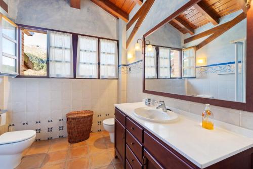 a bathroom with a sink and a toilet andwindows at 4 bedrooms villa with city view private pool and enclosed garden at Bizkaia in Emaldia